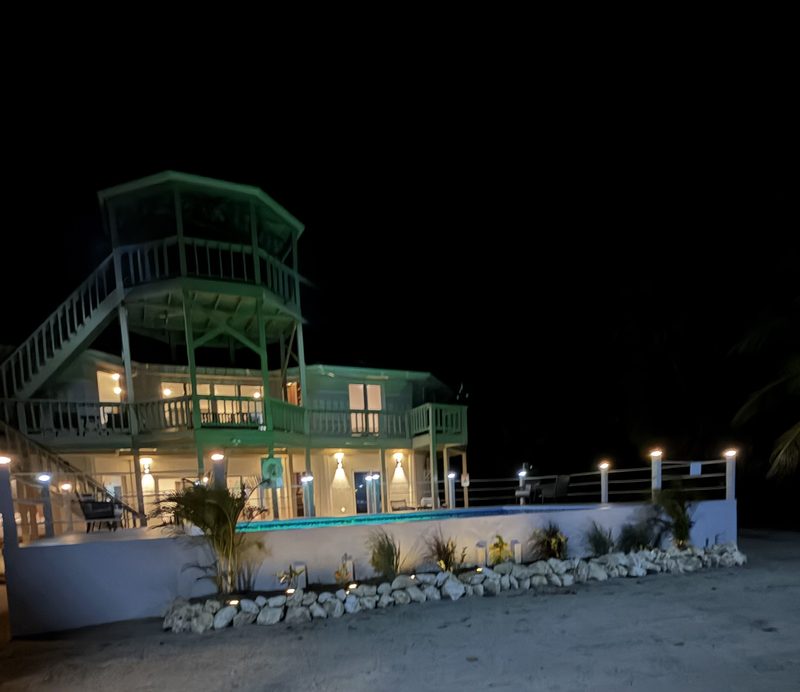 The villa and pool lit up at night